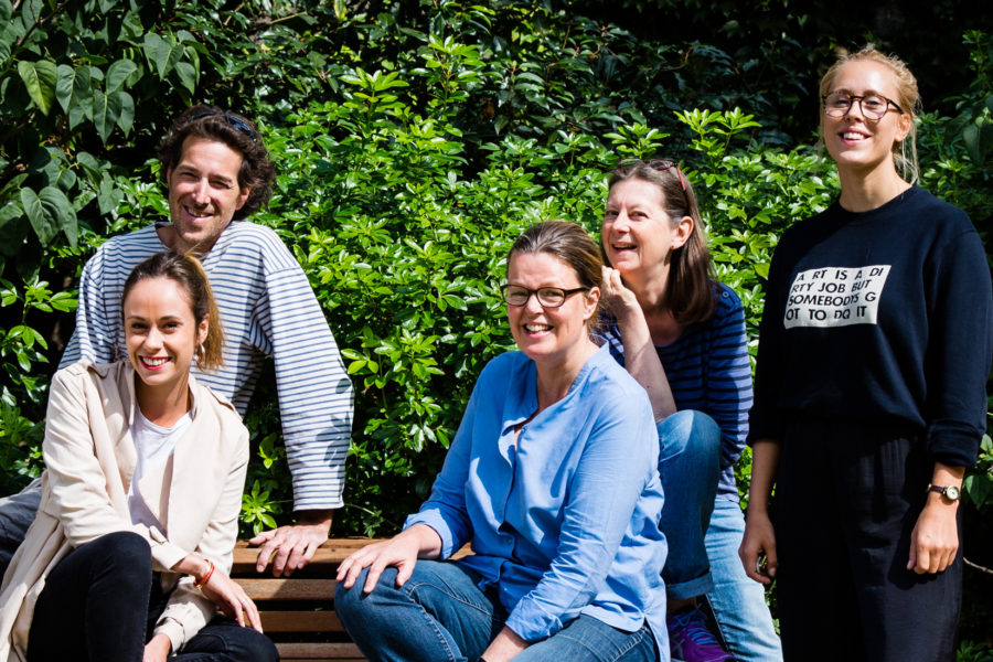 5 personnes sont assises sur un banc et se sourient. 5 personnes sont assises sur un banc et se sourient.
