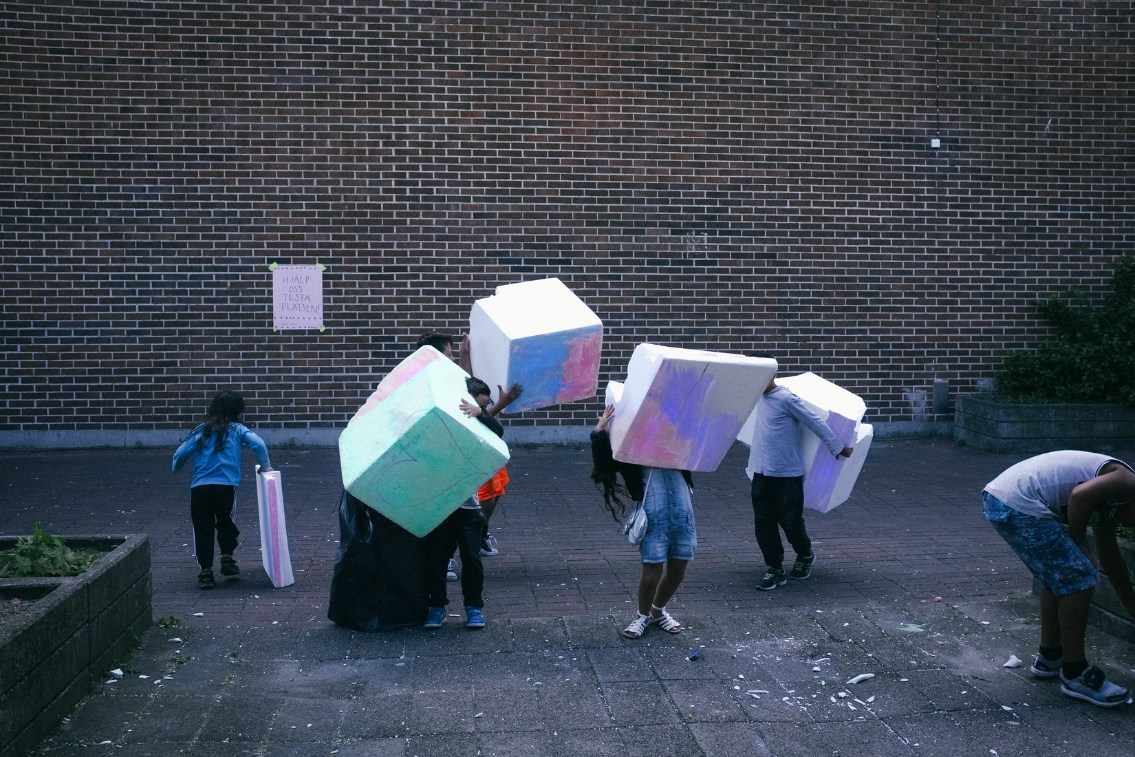 Photo : DISORDER des enfants qui portent des blocs colorés dans la rue