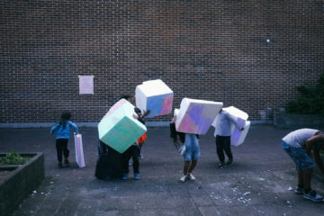 des enfants portent des cubes modulables dans la rue