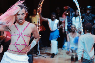 Man dancing and posing with feathers and glitter