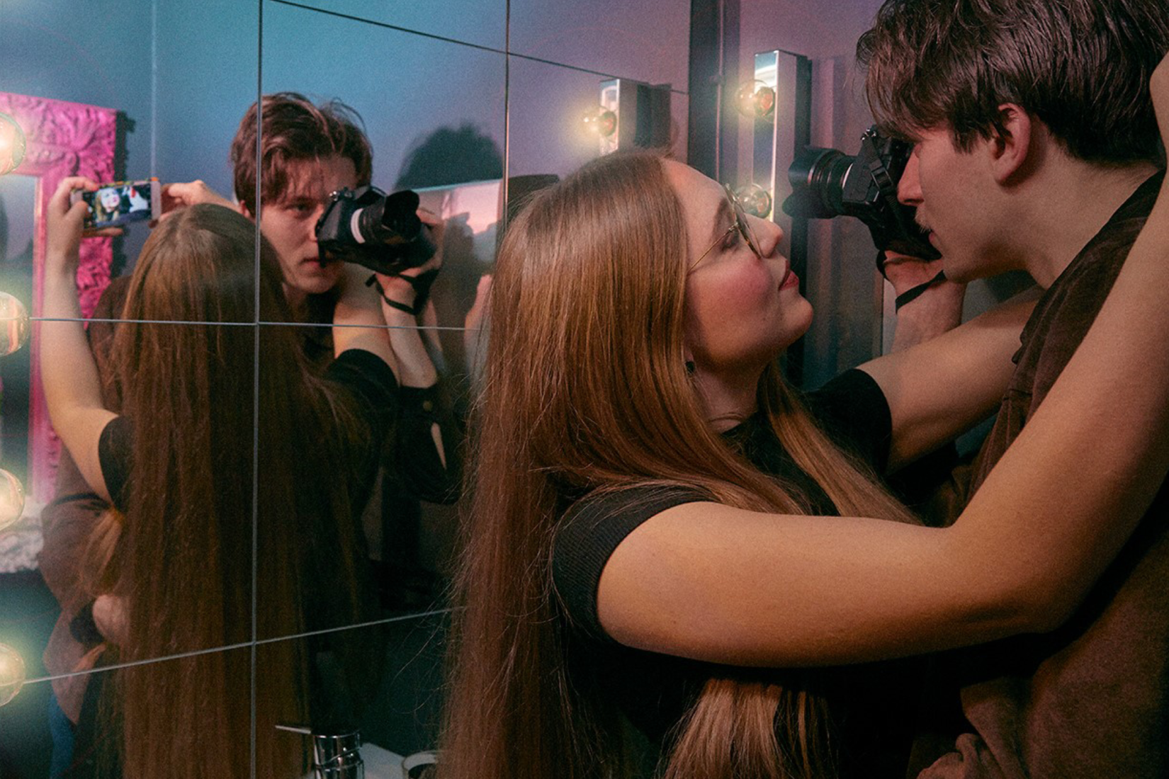A man and a girl about to kiss while filming themselves