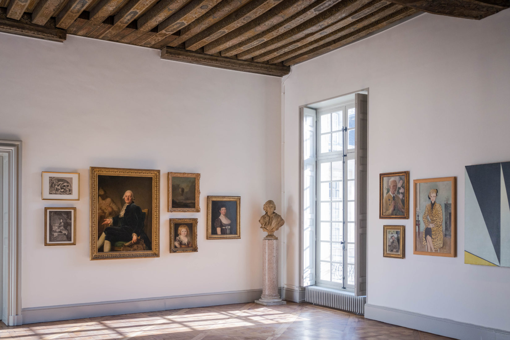 Une salle d'exposition avec plusieurs peintures et dessin