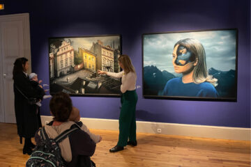 Learning and public engagement curator showing a photograph from Erik Johansson's current exhibition to mothers carrying their babies.