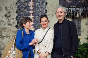 Photographie de Sophie Desrosiers, Mariana Silva Varela et Côme Touvay qui sont face à la caméra, devant deux oeuvres de Kristina Müntzing.