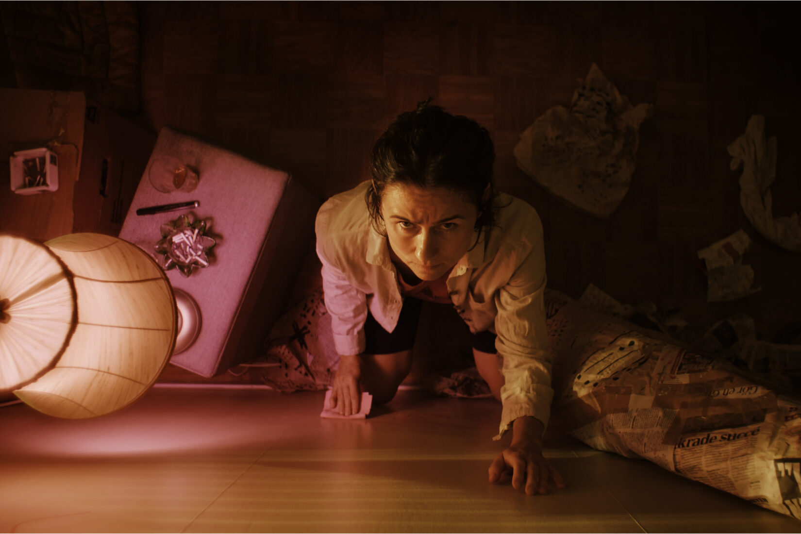 Photo d'une femme en intérieur touchant un mur avec un air concentré et inquiet.