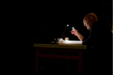 Photo de Lars Norén écrivant à son bureau dans l'obscurité.