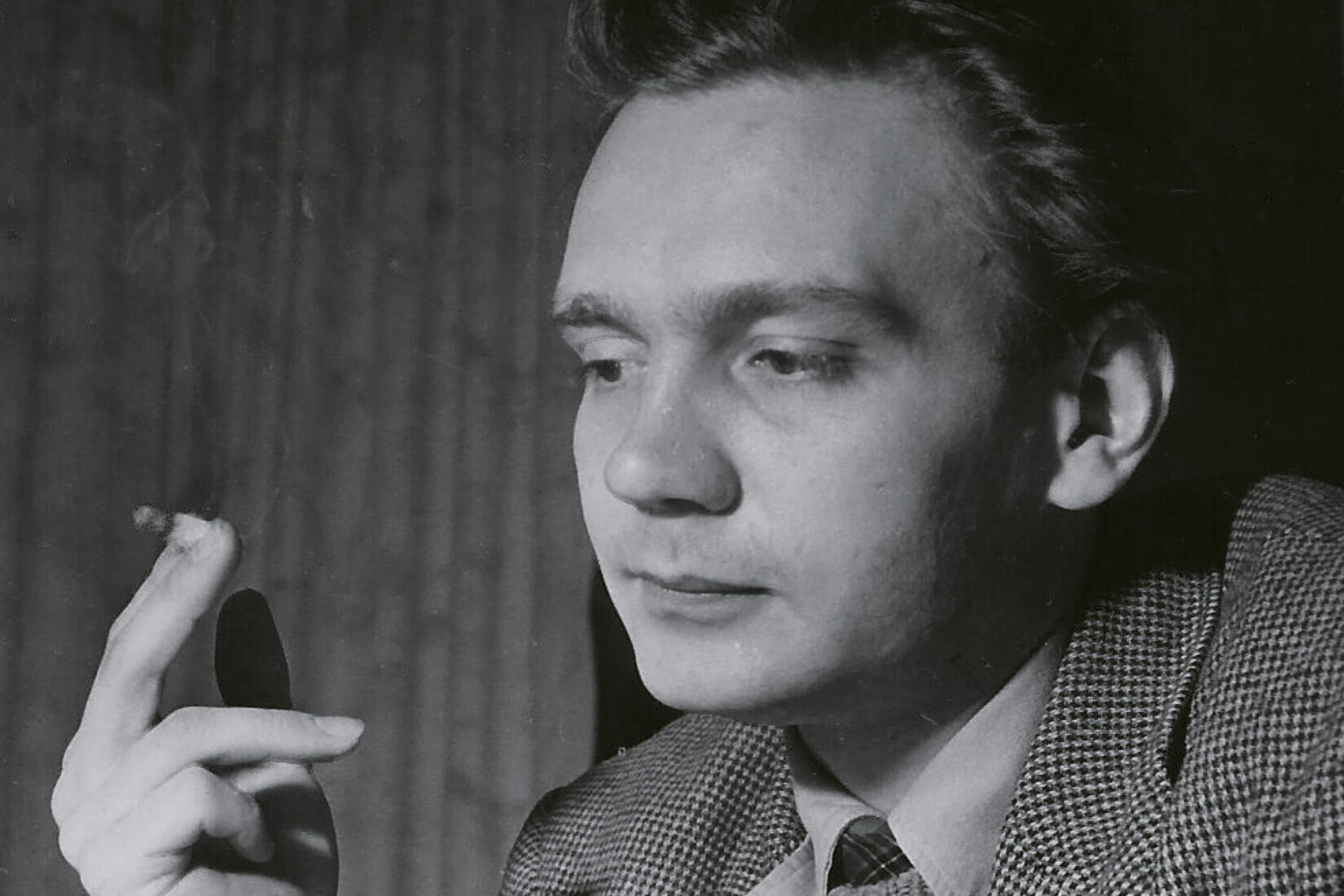 Photo en noir et blanc de Stig Dagerman, fumant une cigarette, le regard baissé.