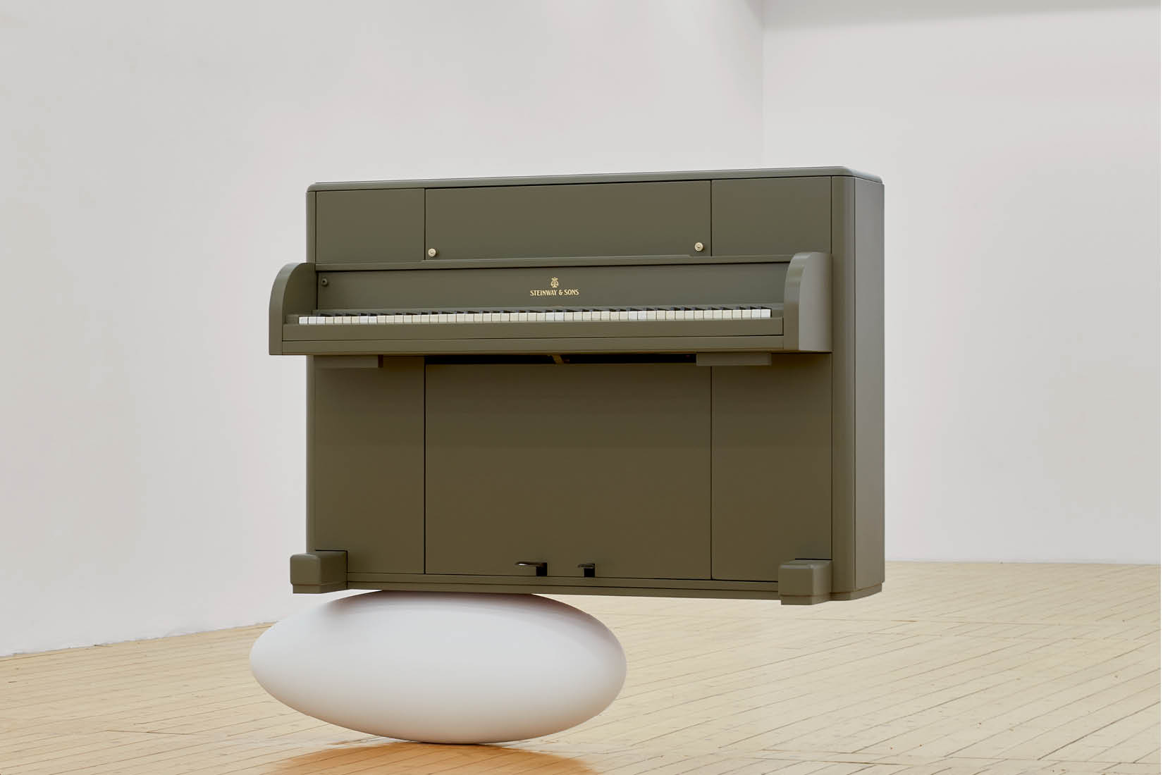 Photo of a piano standing on what looks like a giant egg, in an empty room.