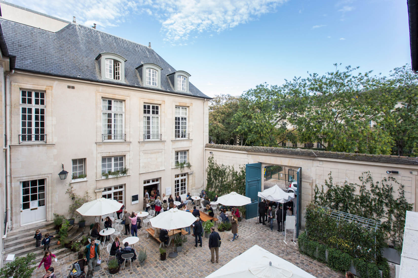 Vue depuis les étages de l'Institut suédois sur la cour, en été, la terrasse du café pleine de monde.