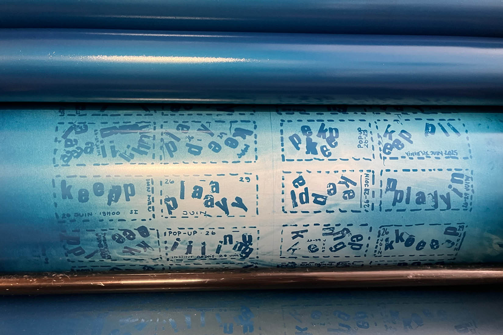 Photo d'une presse avec les lettres composant : KEEP PLAYING