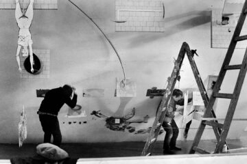 Black and white photo of Barbro Östlihn setting an exhibition.