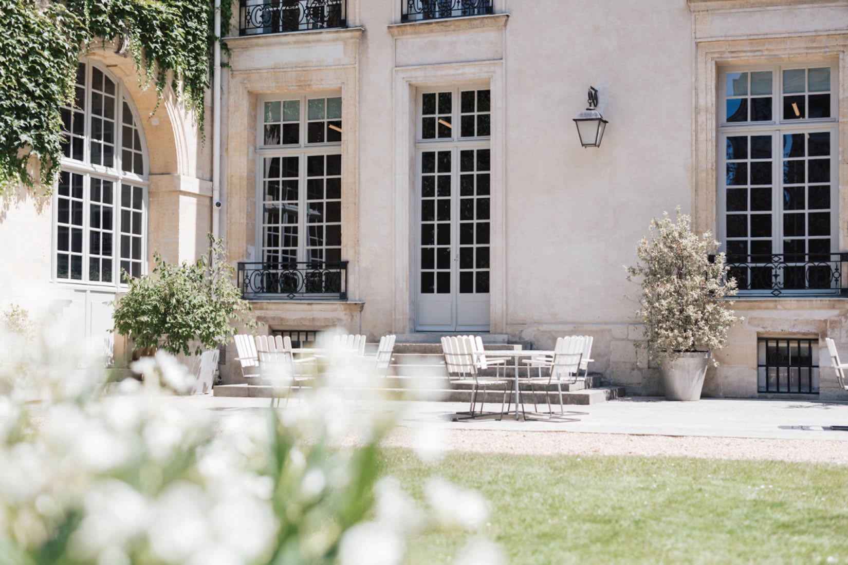 Photo du jardin de l'Institut suédois : pelouse, tables et chaises, façade du bâtiment.