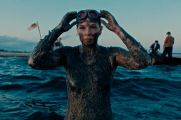 Une femme se relevant de la mer couverte d'algues.