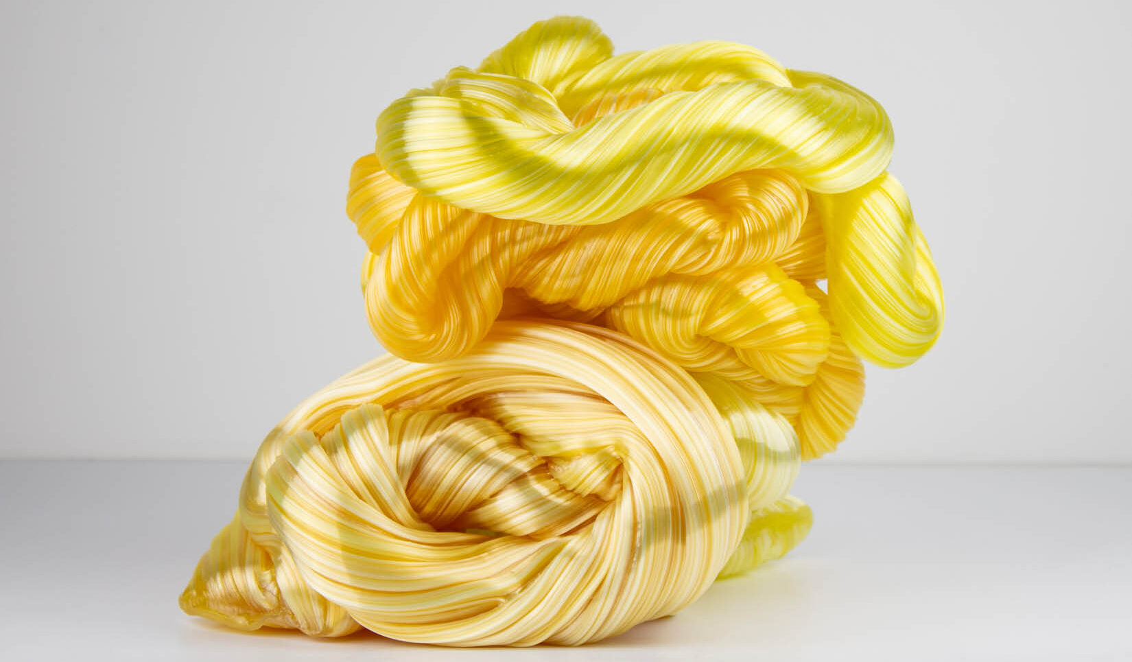 Glass sculpture resembling an intertwined yellow rope.