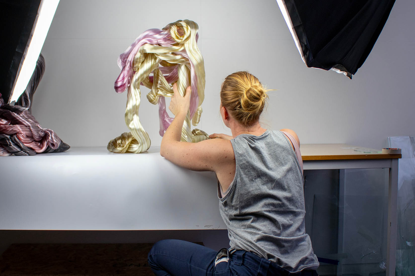 Artist from behind, working on a glass sculpture.