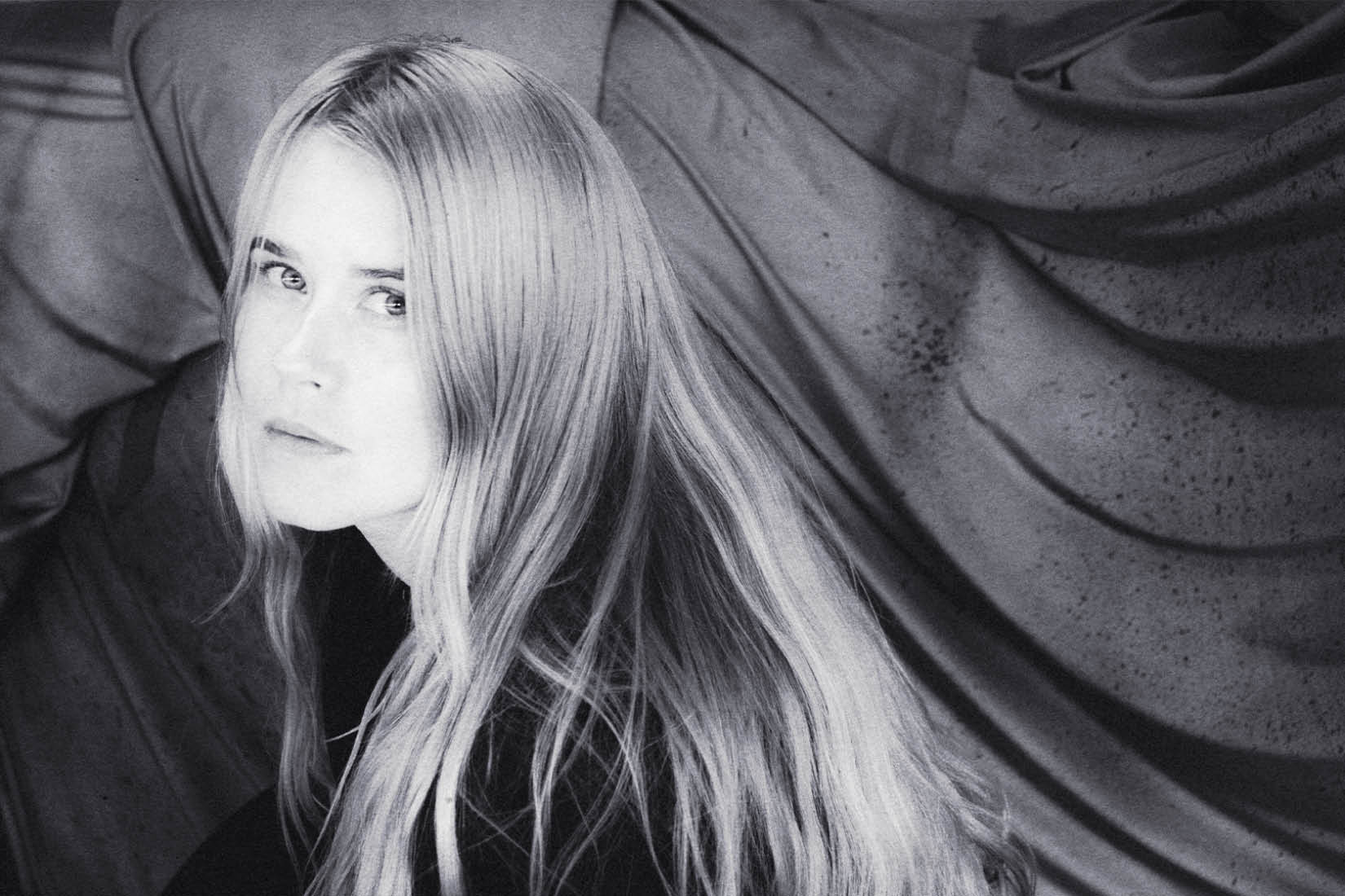 Portrait en noir et blanc de la chanteuse aux longs cheveux clairs.
